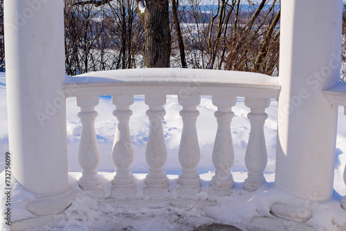 a fragment of a white gazebo in a snow-covered park