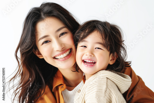 A mother and her young child beam with happiness, sharing a bright, infectious smile against a white background.