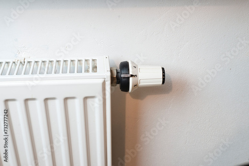 Biały grzejnik z widocznym termostatem na białym tle photo