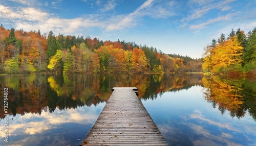 autumn forest landscape reflection on the water with wooden pier