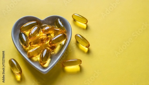 omega 3 capsules in a heart shaped plate on yellow background fish oil softgels supplement food vitamin d capsules copy space image