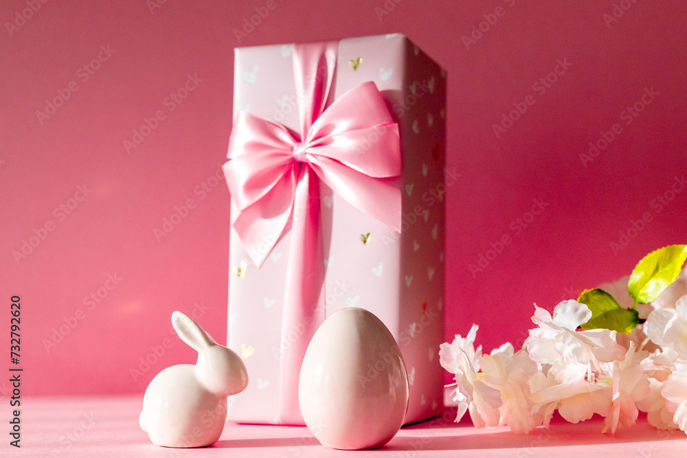 Porcelain Easter eggs and bunny with gift box on a pink background. Porcelain Easter eggs and bunny with gift box on a pink background.
