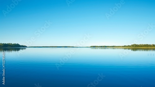 A tranquil lake reflecting the clear blue sky, creating a sense of serenity and inner peace © olegganko