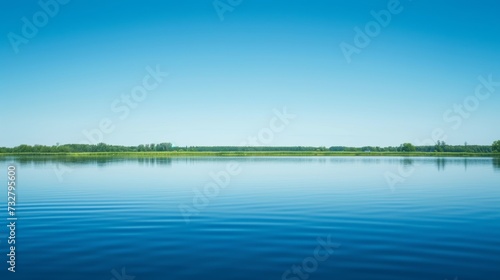 A tranquil lake reflecting the clear blue sky, creating a sense of serenity a...