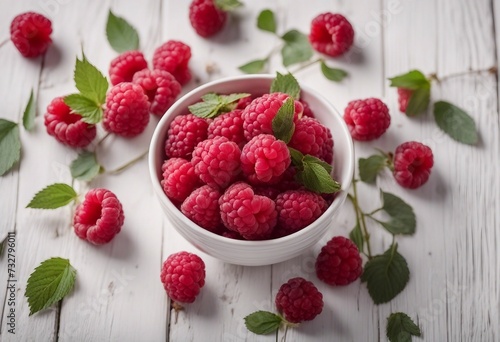 Ripe sweet raspberries in bowl on white wooden background top view