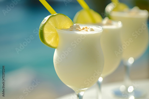 Glasses of creamy Brazilian lemonade with a lime twist at the poolside. Poolside refreshment with frothy limeade, tropical bliss. Sunny poolside sunny day with Brazilian lime beverages