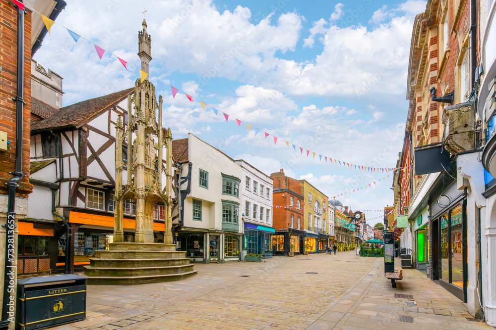 Picturesque half timber frame buildings full of shops near Buttercross Monument on popular High Street in the medieval old town of Winchester, England, UK. - obrazy, fototapety, plakaty 