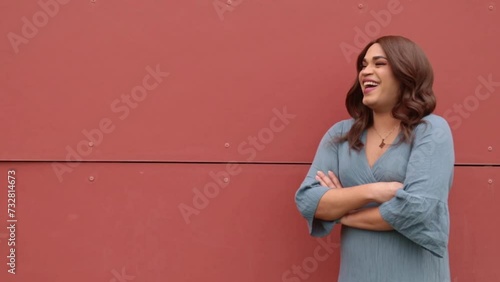 Transsexual woman on a red wall laughing and smiling. Copy space background. photo