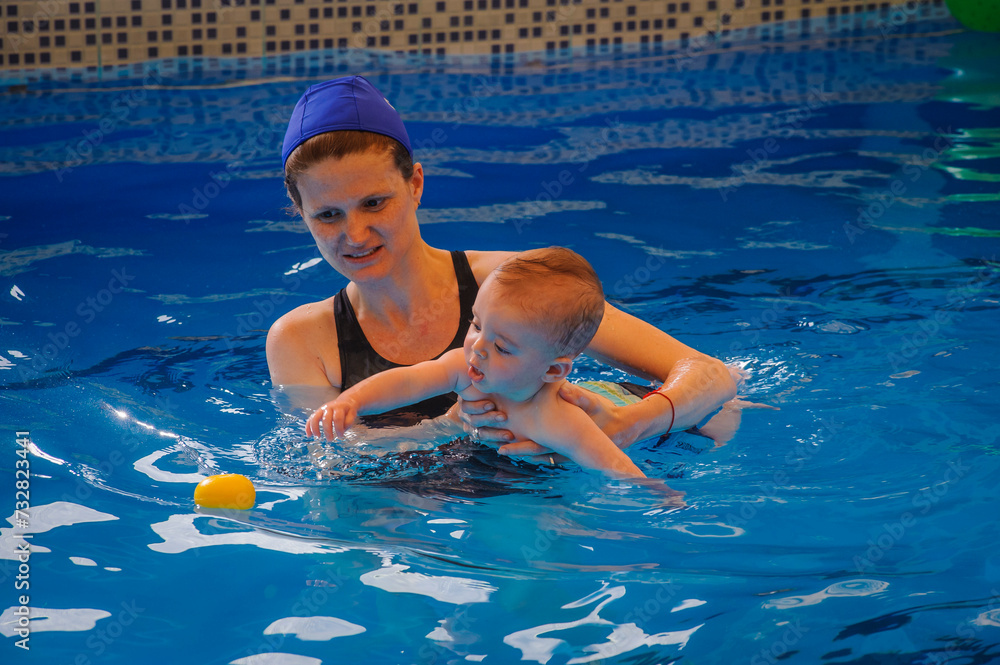A mother and her baby boy in a swimming pool