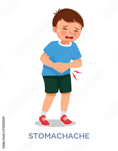 Sick little boy suffering from stomach ache, diarrhea, abdominal pain, gastritis, or food poisoning holding his belly