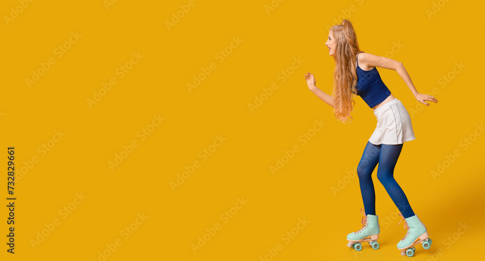 Beautiful young woman in vintage roller skates on yellow background with space for text