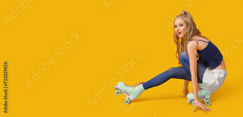 Fototapeta Naklejka Na Ścianę i Meble -  Stylish young woman in vintage roller skates on yellow background with space for text