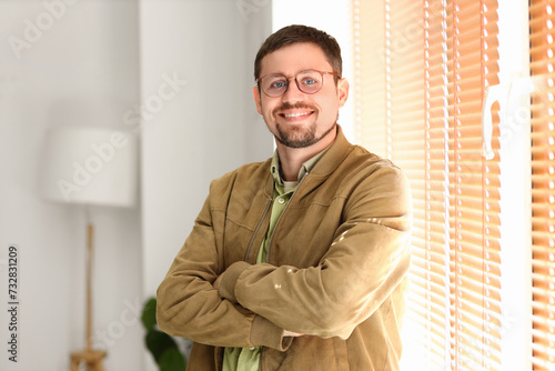 Handsome man in stylish eyeglasses at home