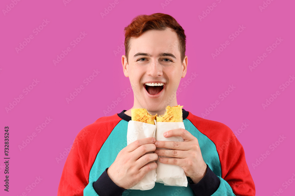 Young man with tasty sandwich wraps on purple background, closeup Young man with tasty sandwich wraps on purple background, closeup
