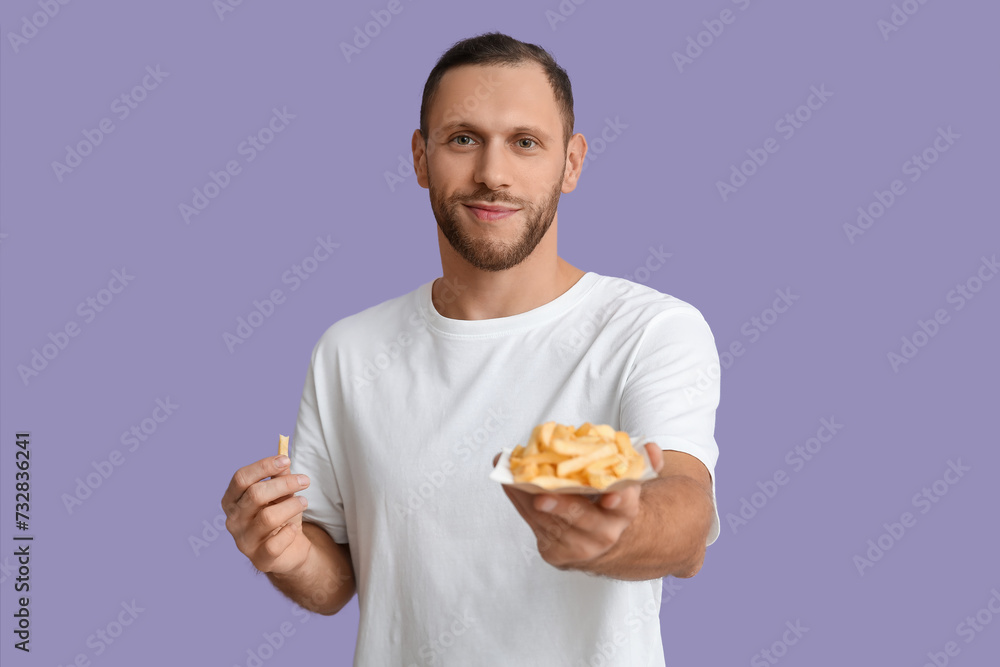 Young man with french fries on purple background Young man with french fries on purple background