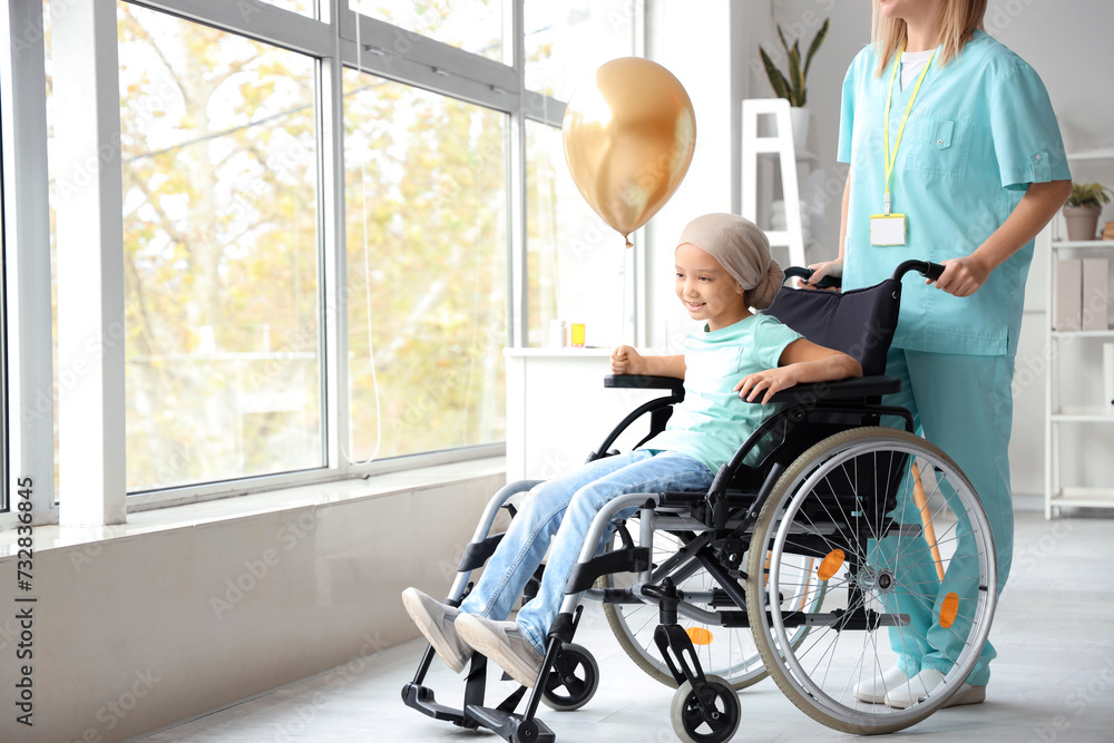 Little Asian girl after chemotherapy in wheelchair with balloon and nurse at hospital Little Asian girl after chemotherapy in wheelchair with balloon and nurse at hospital
