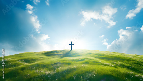 The Cross of Christ in a Green Field on a Sunny Day with White Clouds in the SKy