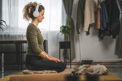 one woman doing guided meditation yoga self care practice at home photo