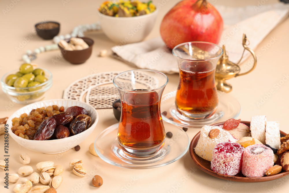 Traditional Eastern dishes, Turkish tea and decorative crescent on beige background. Ramadan celebration