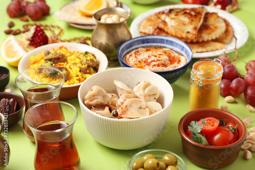 Traditional Eastern dishes on green background, closeup. Ramadan celebration