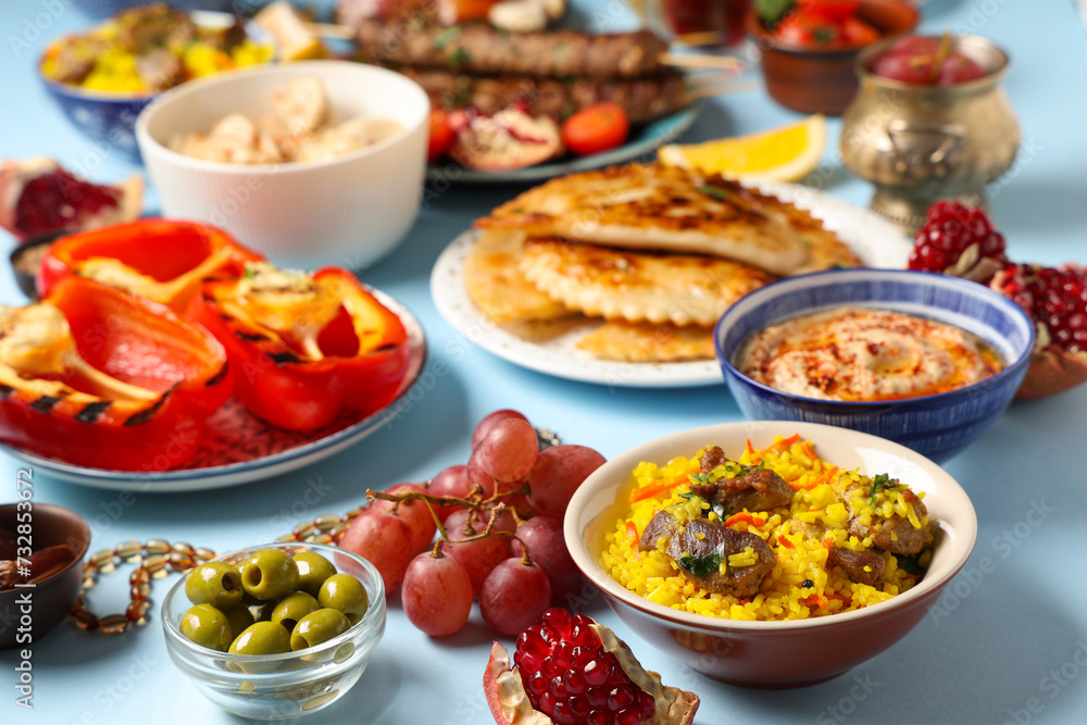 Traditional Eastern dishes on blue background, closeup. Ramadan celebration