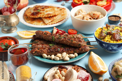Traditional Eastern dishes on blue background, closeup. Ramadan celebration