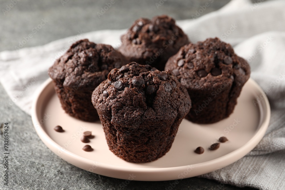 Delicious fresh chocolate muffins on grey table, closeup Delicious fresh chocolate muffins on grey table, closeup