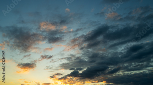 Sunset or sunrise. Dramatic majestic scenery sunset. Sky with clouds in sunset sky light background. Sunrise with clouds in various shapes. Calm sunset sky and sun through clouds over.