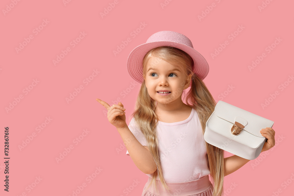Cute little girl with stylish white bag pointing at something on pink background Cute little girl with stylish white bag pointing at something on pink background