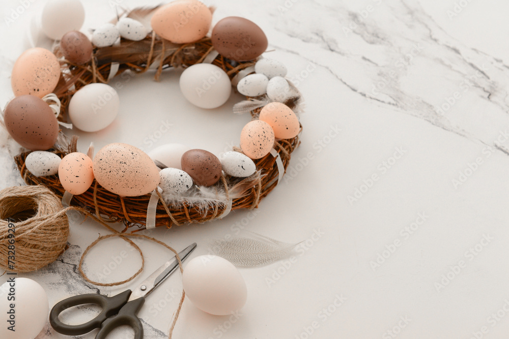 Composition with supplies for creating Easter wreath on white table Composition with supplies for creating Easter wreath on white table