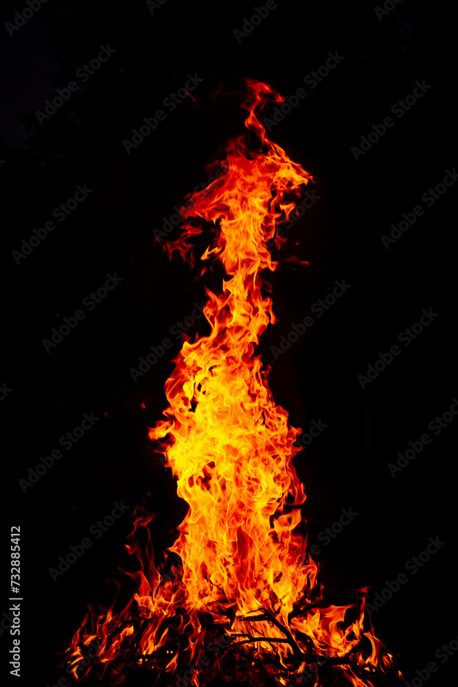 Beautiful vertical shot of a large burning fire at night Beautiful vertical shot of a large burning fire at night