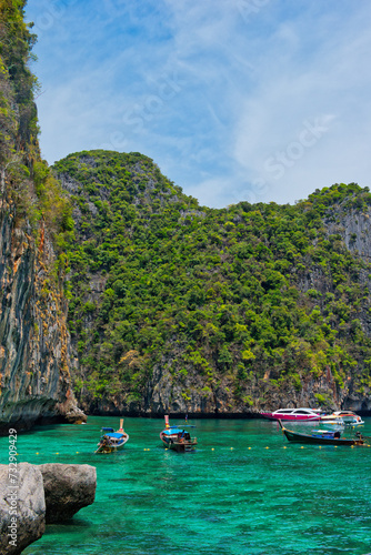 KOH PHI PHI, THAILAND - MARCH 11 2022: Motor boats on turquoise water of Maya Bay lagoon on MARCH 11, 2022 in Koh Phi Phi island, Thailand. This was extremely quiet due to the Covid 19 pandemic.