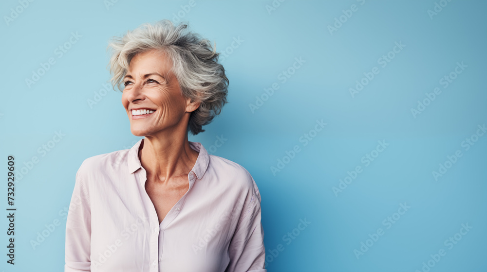 middle aged woman a carefree mature, striking a pose against a pastel blue backdrop middle aged woman a carefree mature, striking a pose against a pastel blue backdrop