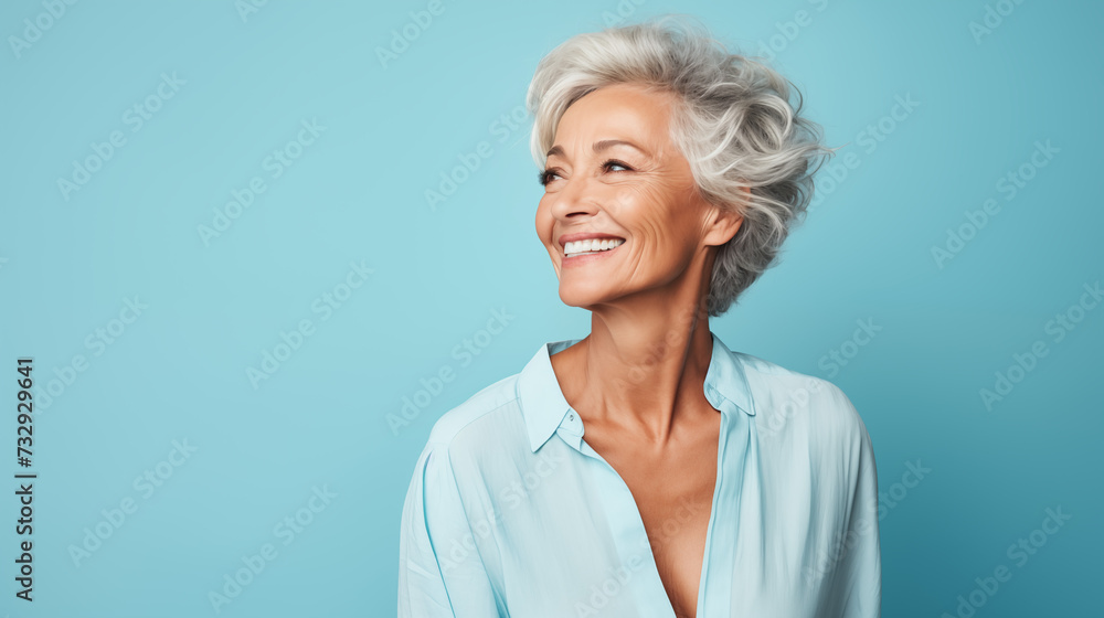 a carefree mature woman, striking a pose against a pastel blue backdrop a carefree mature woman, striking a pose against a pastel blue backdrop