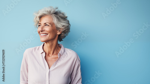 middle aged woman a carefree mature  striking a pose against a pastel blue backdrop