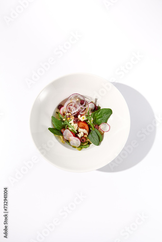 Greek salad with crisp vegetables and feta cheese isolated on white background, top view