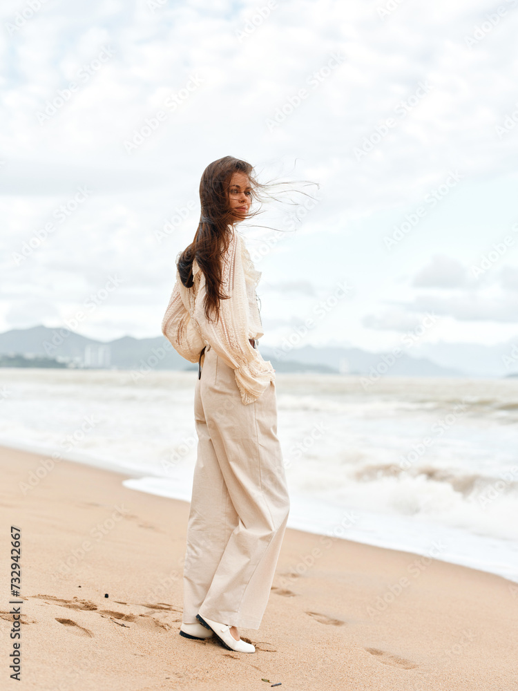 Serene Summer Beauty: A Young Caucasian Woman Sitting Alone on a Sandy Beach, Gazing at the Ocean during a Stunning Sunset Serene Summer Beauty: A Young Caucasian Woman Sitting Alone on a Sandy Beach, Gazing at the Ocean during a Stunning Sunset