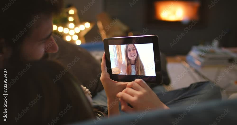 Tablet, wave and video call with couple of friends on sofa in living room of home from back at night. Technology, greeting or virtual visit with people chatting online for communication or connection Tablet, wave and video call with couple of friends on sofa in living room of home from back at night. Technology, greeting or virtual visit with people chatting online for communication or connection