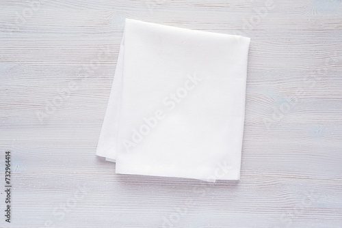 Quadro su tela White plain fabric kitchen towel or tea towel folded on wooden background, mockup for design presentation