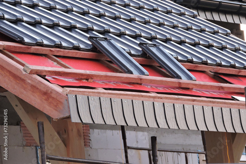 Cuadro en lienzo Installation of graphite roof tiles on wooden beams, a red breather and waterpro