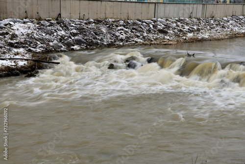 Obraz na płótnie City river milky view between protective walls with a small waterfall w salonie