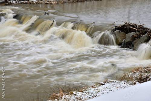Obraz na płótnie City river milky view between protective walls with a small waterfall w salonie