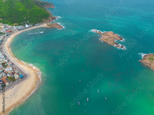 Aerial panorama of Hon Kho seascape, Binh Dinh, Vietnam with clear blue sea, islands and anchored boats. Travel background.
