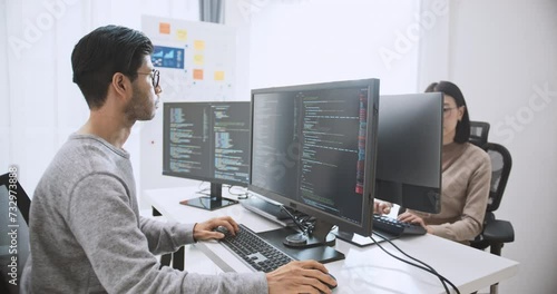 Young adult Asian male, female software developer coding program on desktop computer. Man, woman work from home, remote working, freelance programmer job, smart digital nomad lifestyle concept photo