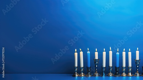 Jewish religious holiday Hanukkah candelabra on blue background.