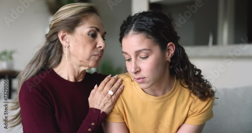 Caring empathetic older mother talking to frustrated young adult daughter, give advice, calming her, show sympathy, supporting in difficult life situation, break up, personal life concerns or divorce photo