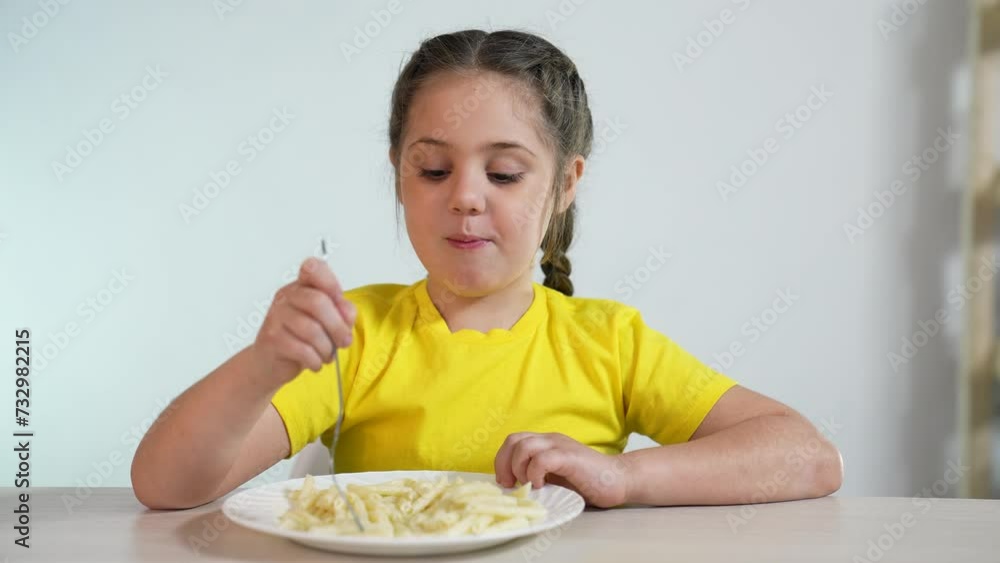 Happy family concept. baby in kindergarten. the child sits eating pasta for lunch. food in kindergarten. happy baby eats delicious pasta. healthy eating in kindergarten. portrait of baby eating pasta Happy family concept. baby in kindergarten. the child sits eating pasta for lunch. food in kindergarten. happy baby eats delicious pasta. healthy eating in kindergarten. portrait of baby eating pasta