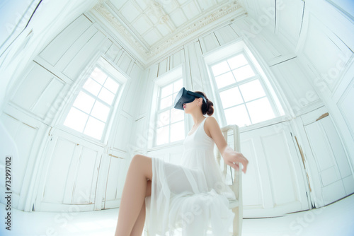 a young woman in wearing virtual reality glasses in a modern white high-tech room