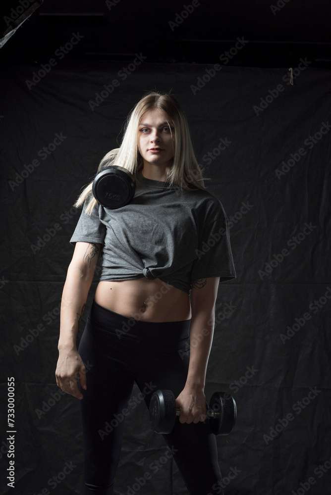 A beautiful young girl is working out in the gym in sportswear. A beautiful young girl is working out in the gym in sportswear.