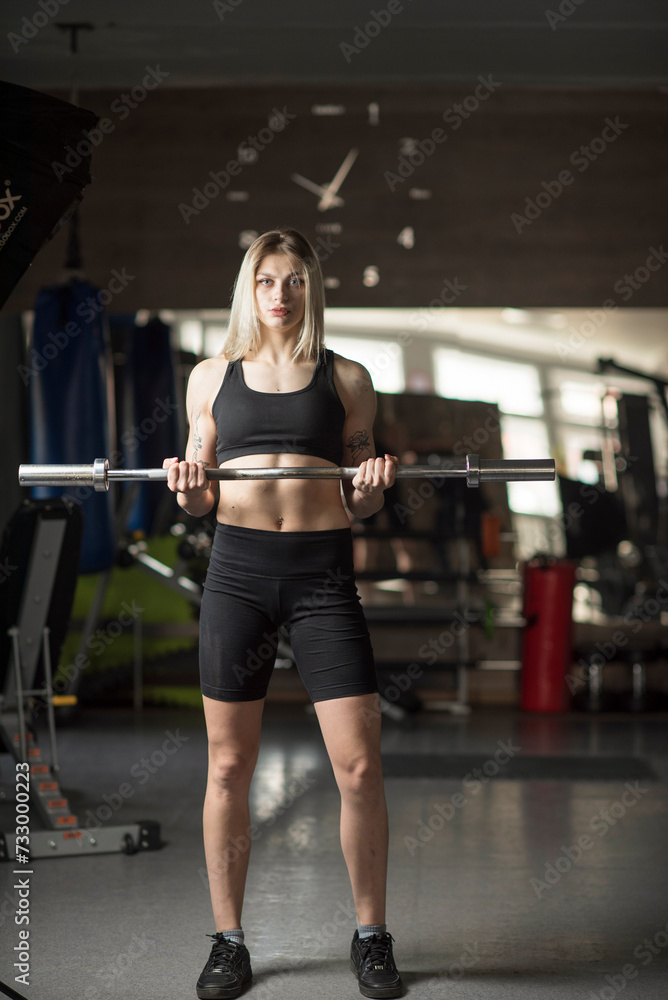 A beautiful young girl is working out in the gym in sportswear. A beautiful young girl is working out in the gym in sportswear.